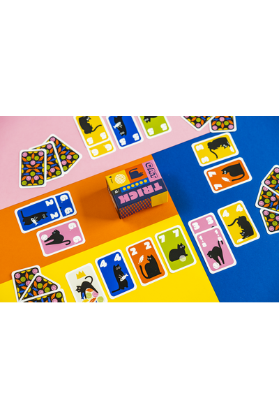 Draufsicht auf ein buntes Stichkartenspiel namens „Cat Trick". Auf einem vierfarbigen Hintergrund aus Pink, Orange, Gelb und Blau sind zahlreiche Spielkarten ausgebreitet. Die Karten zeigen schwarze Katzensilhouetten auf farbigen Hintergründen (Pink, Blau, Gelb, Orange, Grün) mit weißen Zahlen in den Ecken. In der Bildmitte steht die kleine quadratische Spielschachtel mit dem Aufdruck „Cat Trick". Links liegen einige Karten mit dekorativem Rückenmuster aus Blättern, Wollknäueln und Fischen.