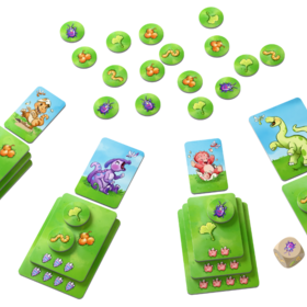 Spielmaterial von „Kleine Dinos" auf weißem Hintergrund. Vier Spielbereiche sind kreisförmig angeordnet, jeder mit gestapelten grünen Karten unterschiedlicher Größe (die wachsenden Dinos), einem runden Futter-Chip obenauf und weiteren Chips daneben. In der Mitte liegen verstreut viele runde grüne Plättchen mit verschiedenen Futtersymbolen (Raupen, Beeren, Blätter) sowie ein Holzwürfel mit Insektenmotiv. Einzelne Dino-Karten zeigen Illustrationen der verschiedenen Dinosaurier.